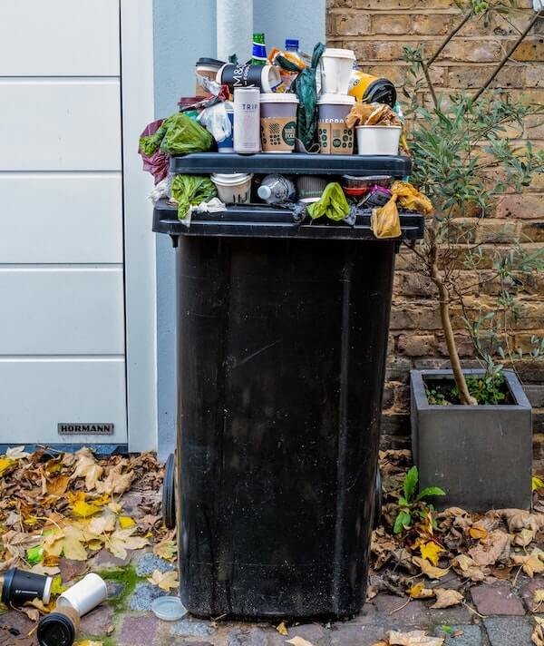 An overfilled garbage can with household trash