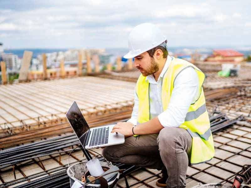 construction worker using laptop on site