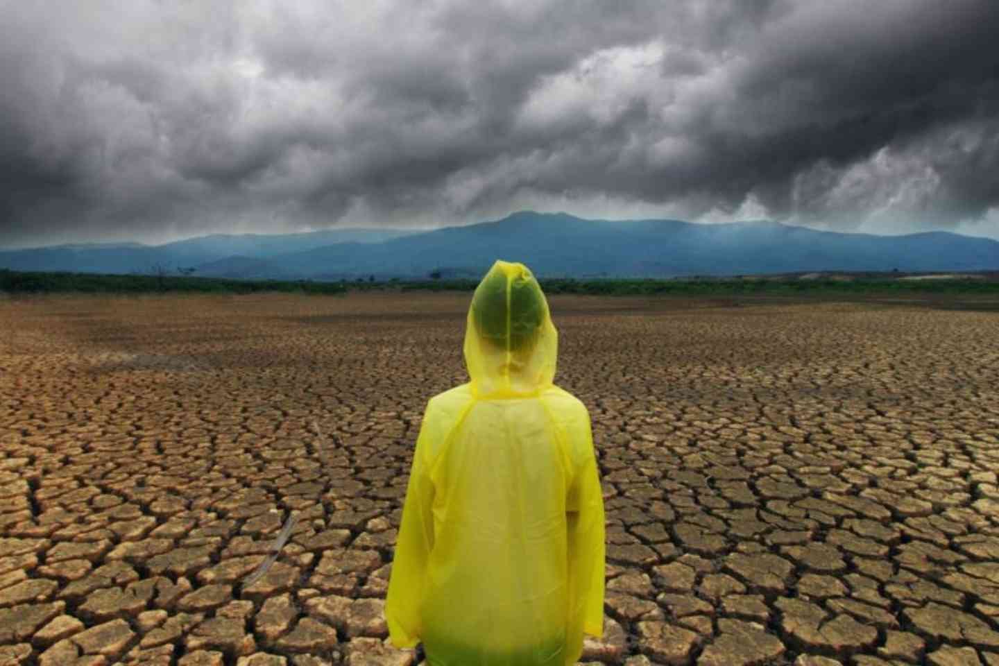 Person wearing poncho looking at storm coming