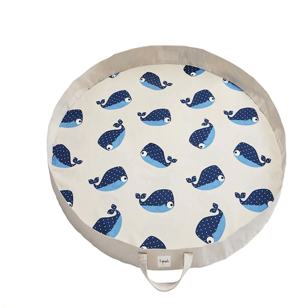 Round white play mat with blue whales on it