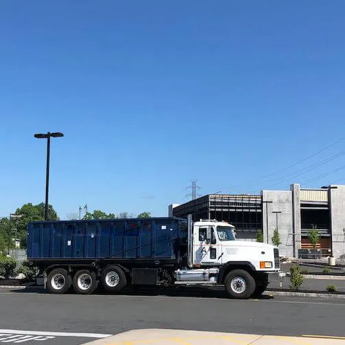 Image of roll off bin truck driving down the street