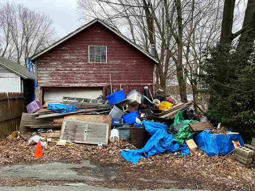 A picture of a house with a lot of junk in front