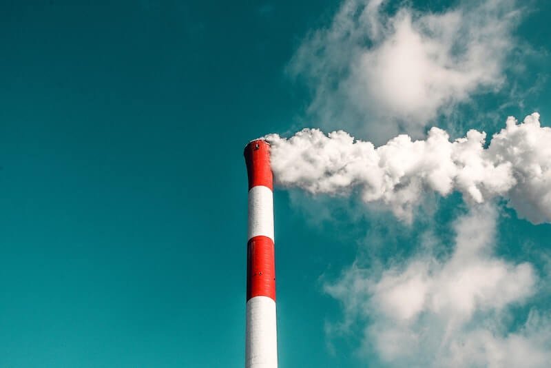 A red and white smoke static in a blue sky with smoke