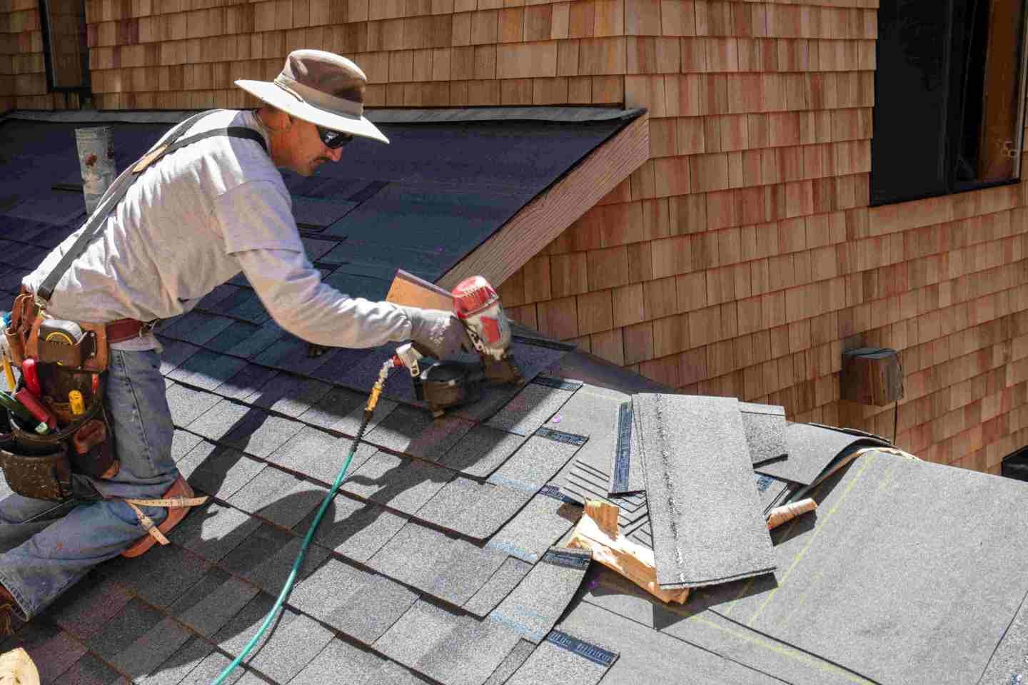 Man installing shingles on roof