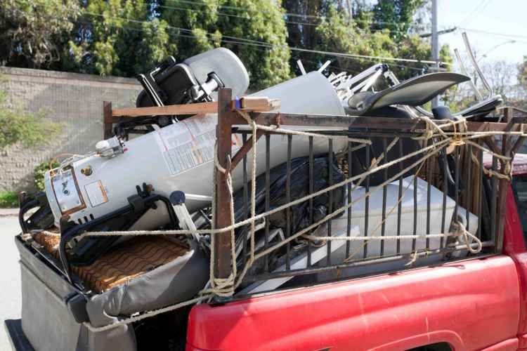 A junk removal truck driving around to pickup dirt