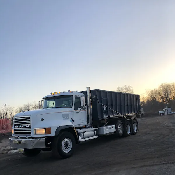 30 yard dumpster on a roll off truck in the sunrise