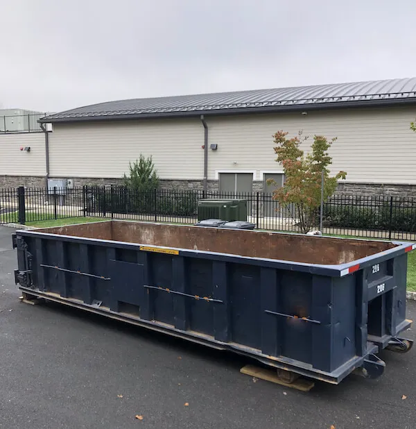 Empty dumpster outside of fence in Miami Dade County