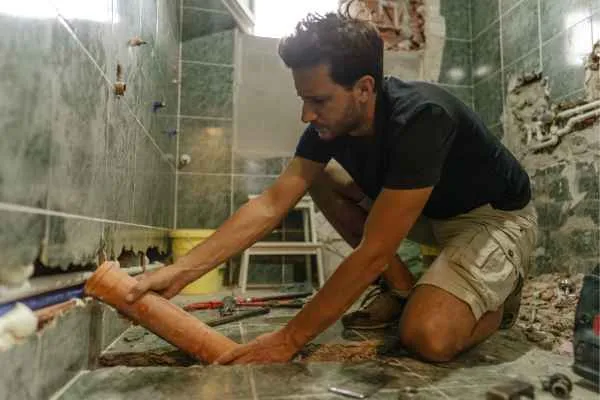 man demolishing his bathroom for renovation
