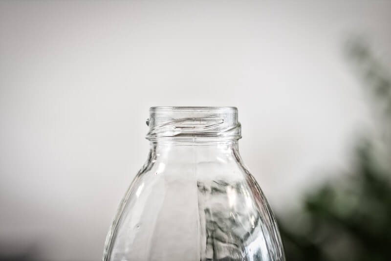 A clear glass bottle ready to be recycled