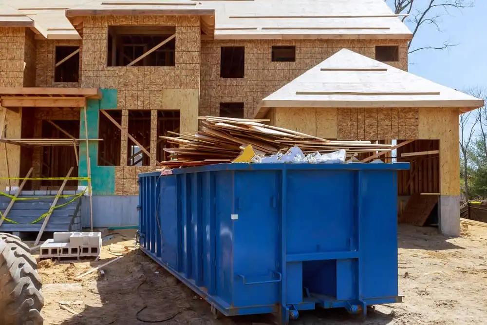 Blue dumpster by house being built
