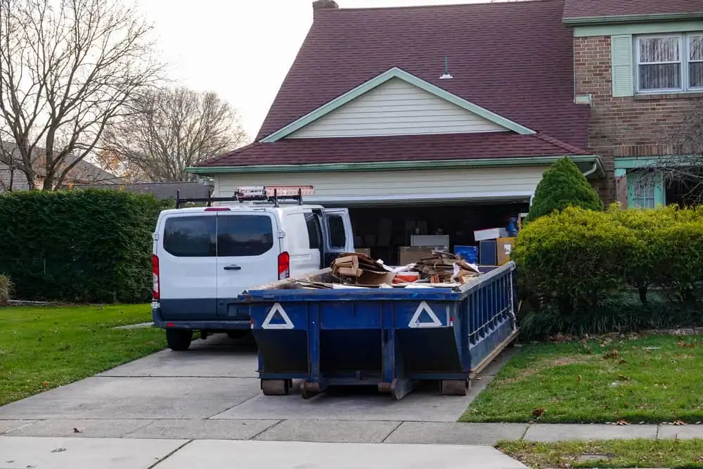 Blue dumpster in front of home