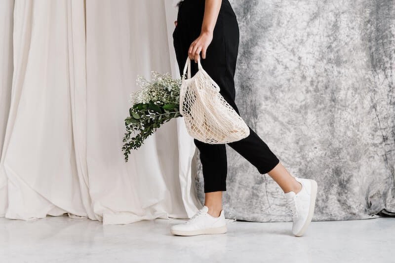A women walking with a reusable bag and flowers