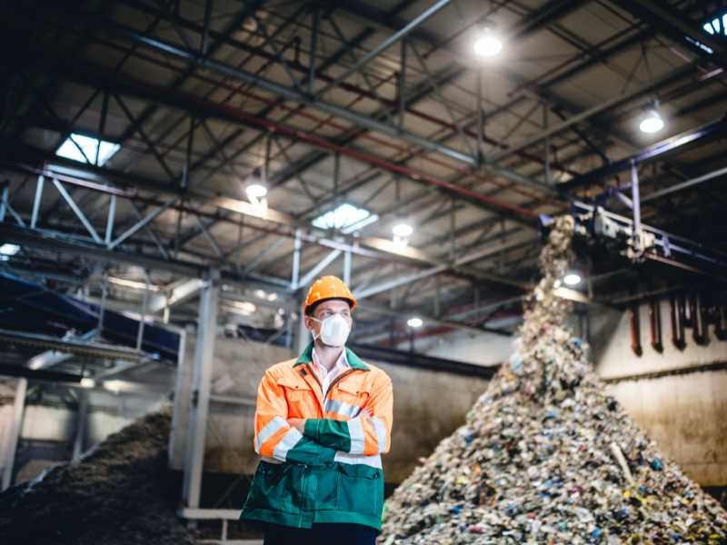waste industry employee standing in a sorting station